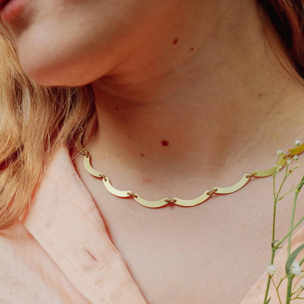 Sustainable Brass Scallop Choker NecklaceThis piece hosts 19 brass scallops that are individually hand finished and delicately attached with gold plated jump rings.