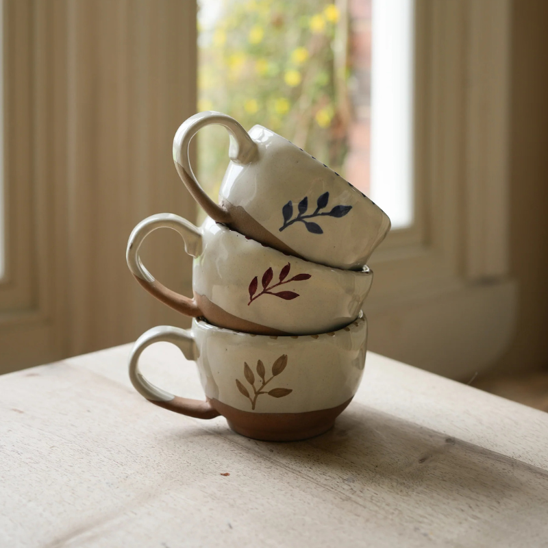 Three ceramic mugs stacked on a table - Uneeka