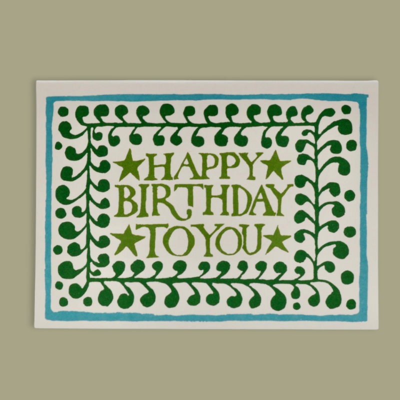 A greeting card with a blue and green border featuring a 'Happy Birthday to you' message in the center, surrounded by decorative stars, printed on a cream background. Gifting at Uneeka.