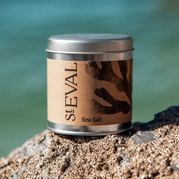 St. Eval sea salt tin on a rocky surface with a blurred natural cornwall background