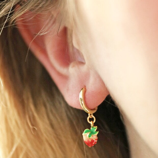 Tiny Coloured Enamel Strawberry Huggie Hoop Earrings being worn