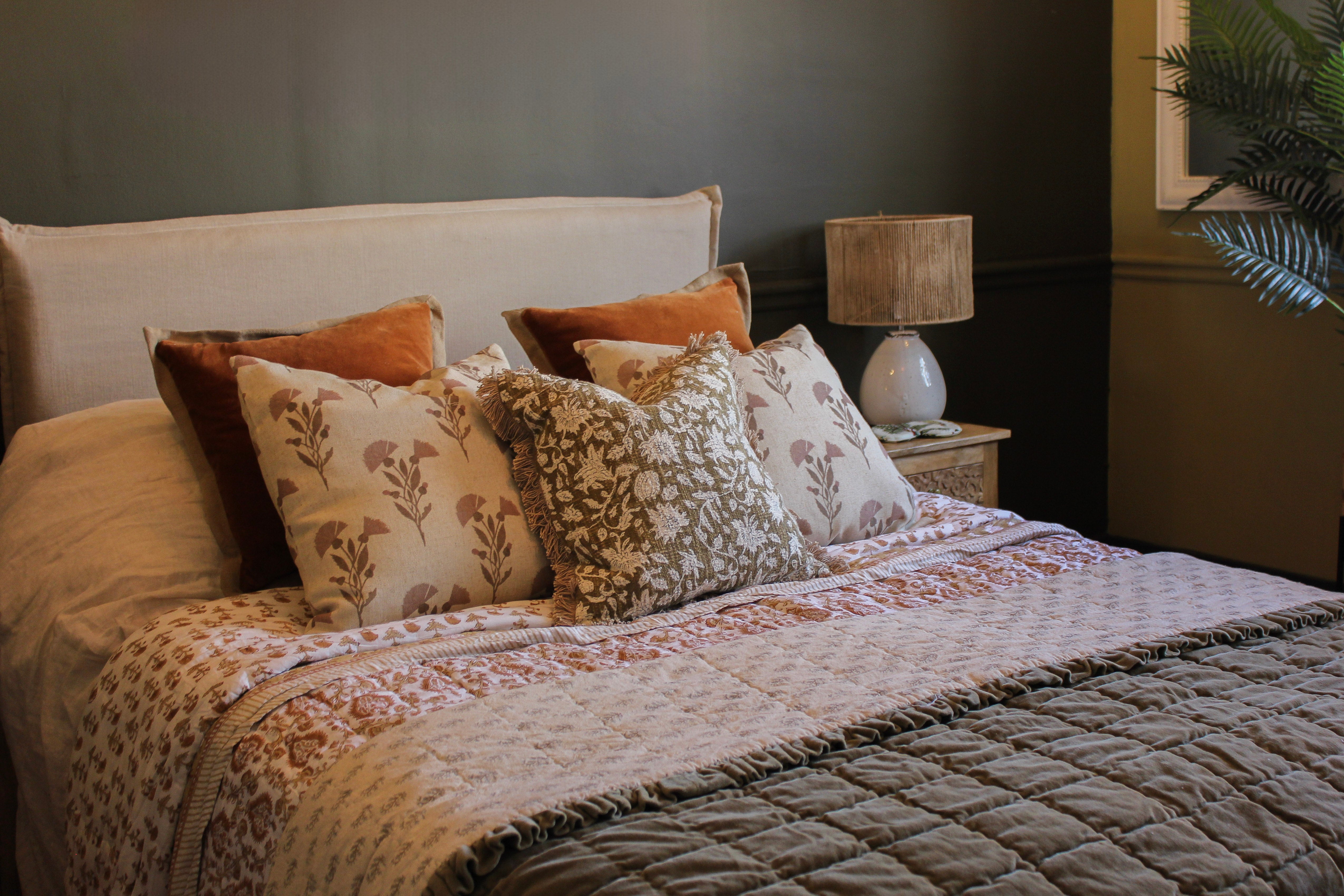 Uneeka Block Print Throws & Cushions Summer 2026, velvet & linen cushions with linen bed fame against dark grey wall