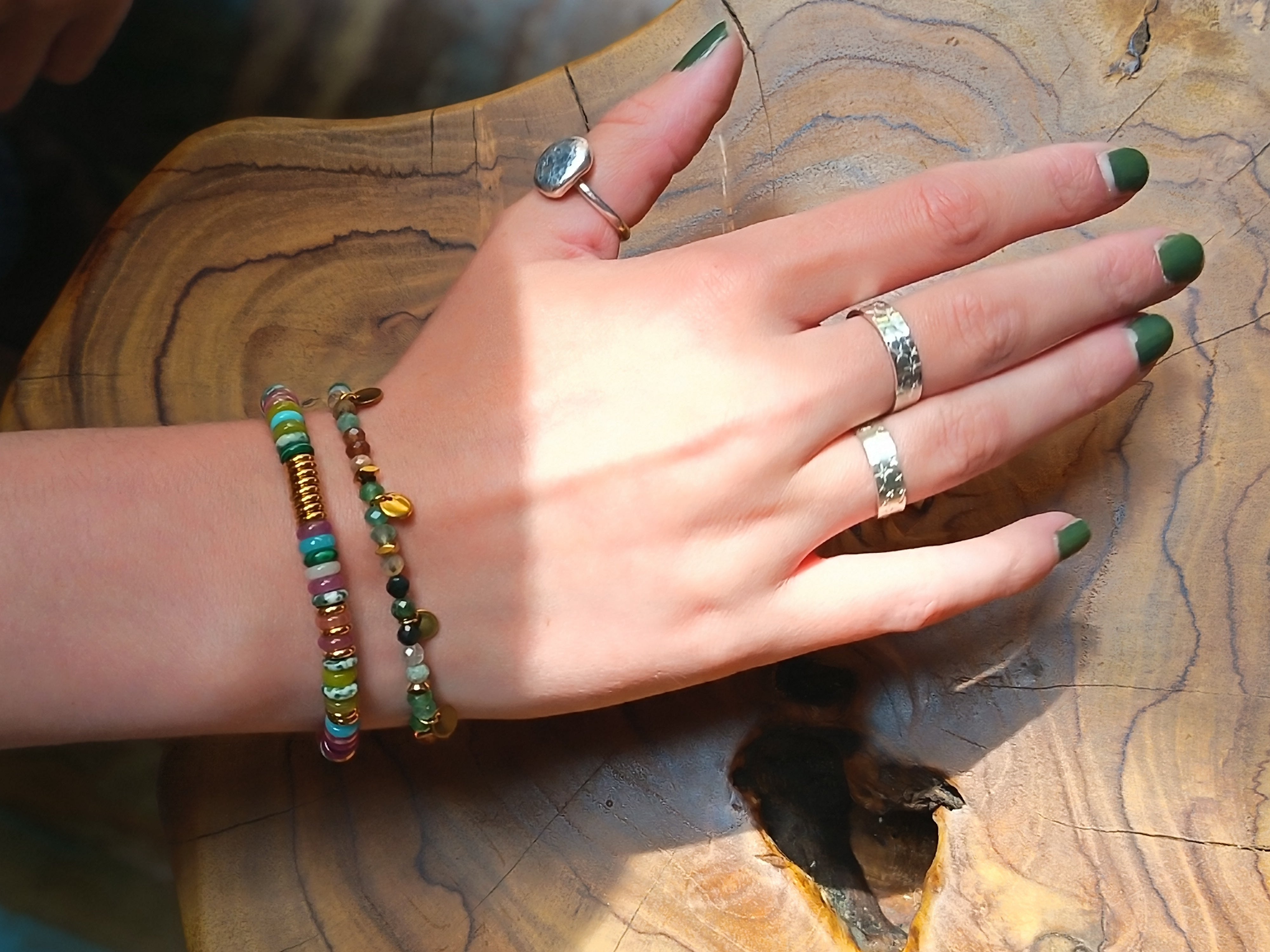 Uneeka Sterling Silver Rings on hand above teak root stool 
