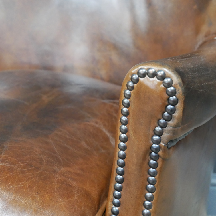 Brown Leather Cosy Chair close up brass gold detailing on arm