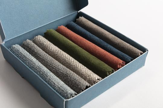A selection of Swyft fabric swatches folded in a box