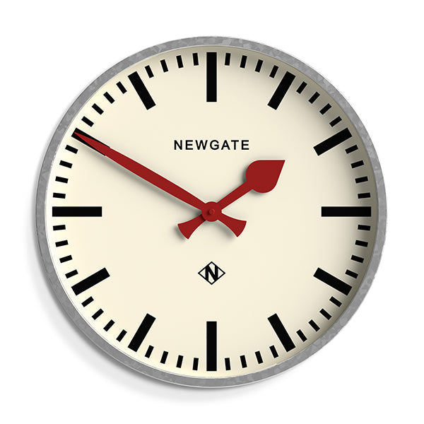 A large galvanised station wall clock with a bold marker dial, contrasting red hands and deep straight-cut metal case with a galvanised finish